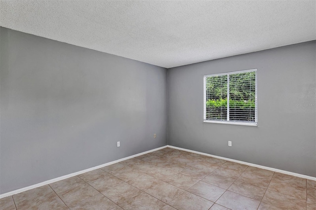 2864 N Powers Dr Unit 150, Orlando, FL 32818 - tiled empty room featuring a textured ceiling and baseboards