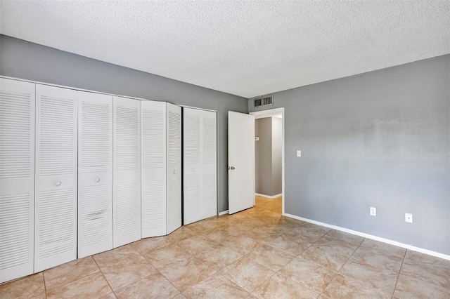 2864 N Powers Dr Unit 150, Orlando, FL 32818 - unfurnished bedroom featuring a textured ceiling, baseboards, and light tile patterned flooring