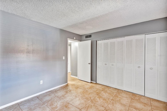 2864 N Powers Dr Unit 150, Orlando, FL 32818 - unfurnished bedroom with tile patterned flooring, a textured ceiling, baseboards, and a closet