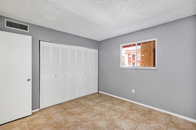 2864 N Powers Dr Unit 150, Orlando, FL 32818 - unfurnished bedroom featuring a textured ceiling, a closet, and baseboards