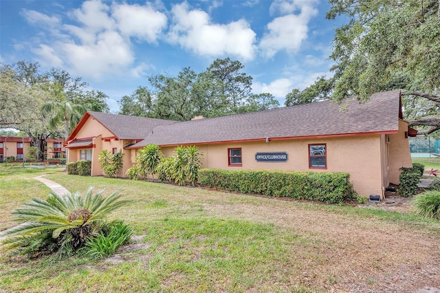 2864 N Powers Dr Unit 150, Orlando, FL 32818 - view of front facade featuring stucco siding, a front lawn, and roof with shingles