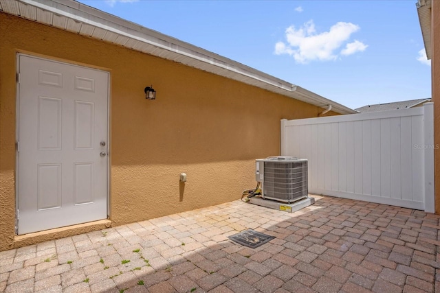 13758 Daniels Landing Cir, Winter Garden, FL 34787 - view of exterior entry featuring central air condition unit, stucco siding, a patio, and fence