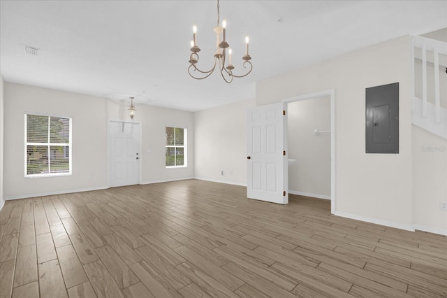 13758 Daniels Landing Cir, Winter Garden, FL 34787 - unfurnished room featuring electric panel, light wood-style flooring, a chandelier, and baseboards
