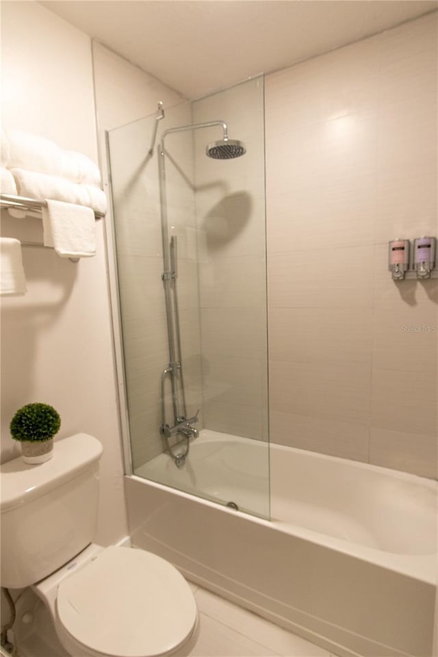 5245 W Irlo Bronson Memorial Hwy Unit 148, Kissimmee, FL 34746 - bathroom featuring toilet, bath / shower combo with glass door, and tile patterned flooring