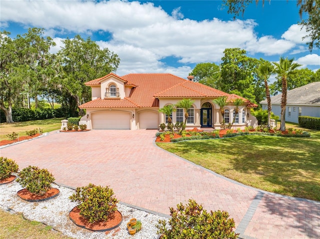 1654 Marina Lake Dr, Kissimmee, FL 34744 - mediterranean / spanish house with stucco siding, decorative driveway, a tiled roof, a front lawn, and an attached garage