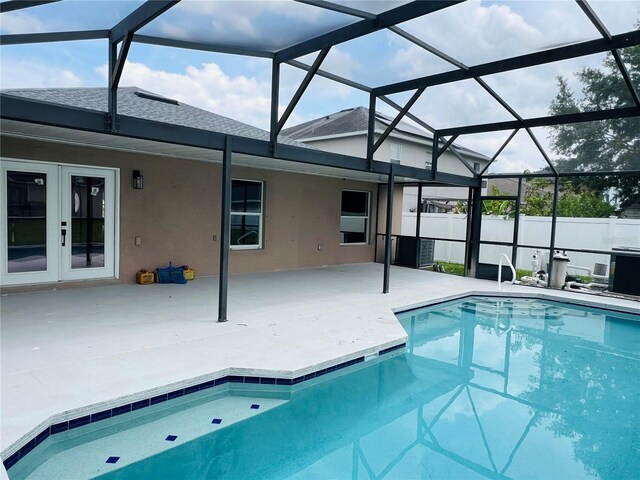 outdoor pool featuring a patio, french doors, a lanai, and fence