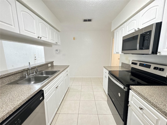 2330 Prime Cir Unit A, Kissimmee, FL 34746 - kitchen featuring appliances with stainless steel finishes, a sink, a textured ceiling, white cabinets, and baseboards