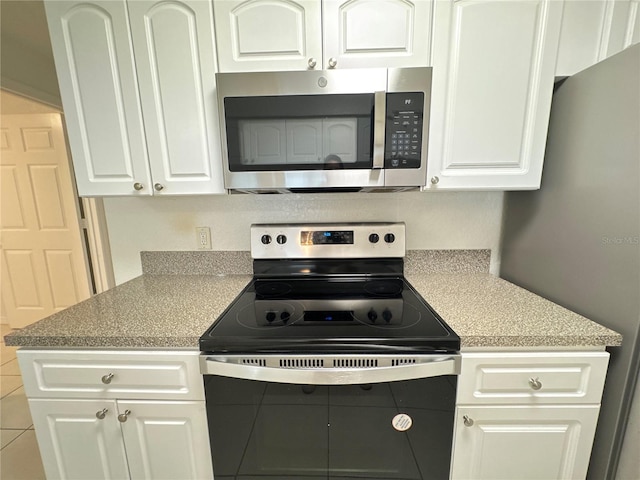 2330 Prime Cir Unit A, Kissimmee, FL 34746 - kitchen featuring stainless steel microwave, electric stove, white cabinetry, and light countertops