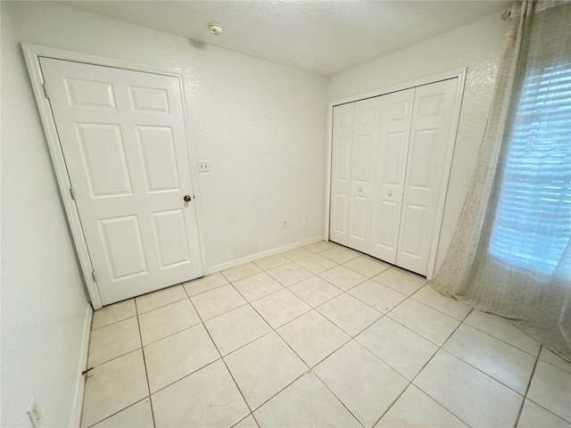 2330 Prime Cir Unit A, Kissimmee, FL 34746 - unfurnished bedroom featuring light tile patterned floors, a closet, and baseboards