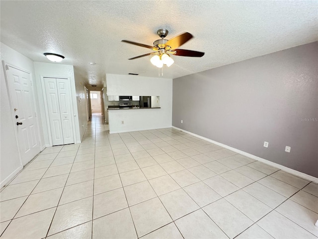 2330 Prime Cir Unit A, Kissimmee, FL 34746 - unfurnished living room featuring a textured ceiling, a ceiling fan, baseboards, and light tile patterned floors
