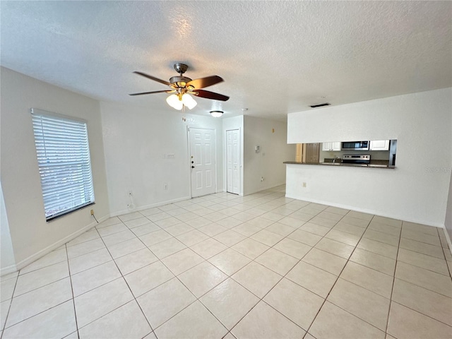 2330 Prime Cir Unit A, Kissimmee, FL 34746 - unfurnished living room featuring ceiling fan, a textured ceiling, and light tile patterned floors