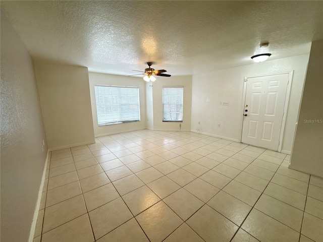 2330 Prime Cir Unit A, Kissimmee, FL 34746 - spare room with a textured ceiling, light tile patterned floors, a ceiling fan, and baseboards