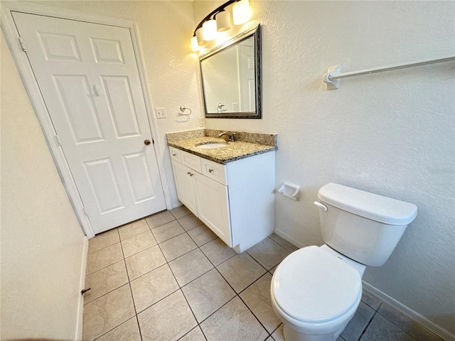 2330 Prime Cir Unit A, Kissimmee, FL 34746 - bathroom with toilet, vanity, tile patterned flooring, baseboards, and a textured wall