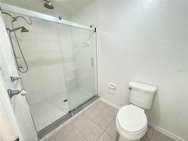 2330 Prime Cir Unit A, Kissimmee, FL 34746 - bathroom with a shower stall, baseboards, toilet, tile patterned floors, and a textured wall