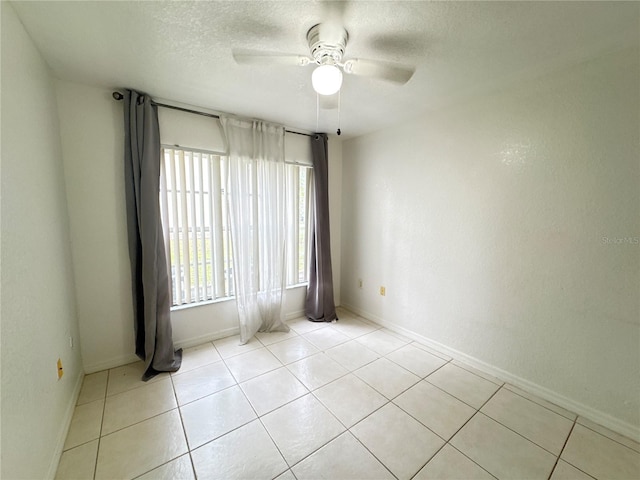 2330 Prime Cir Unit A, Kissimmee, FL 34746 - empty room with a ceiling fan, light tile patterned flooring, baseboards, and a textured ceiling