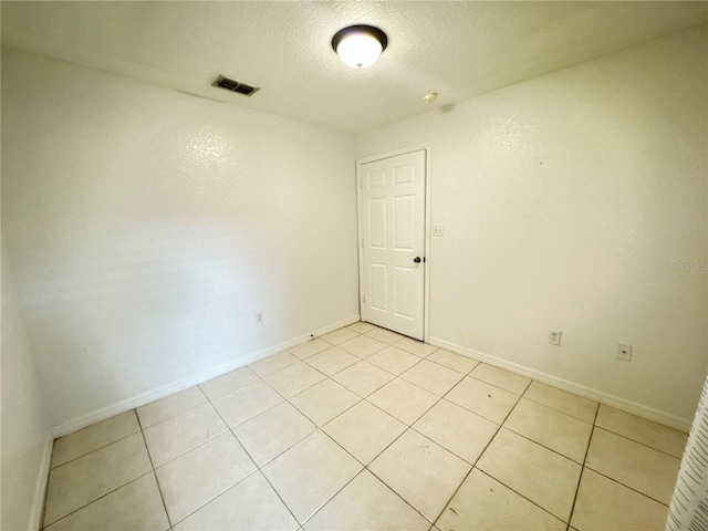 2330 Prime Cir Unit A, Kissimmee, FL 34746 - empty room with a textured ceiling, light tile patterned flooring, and baseboards