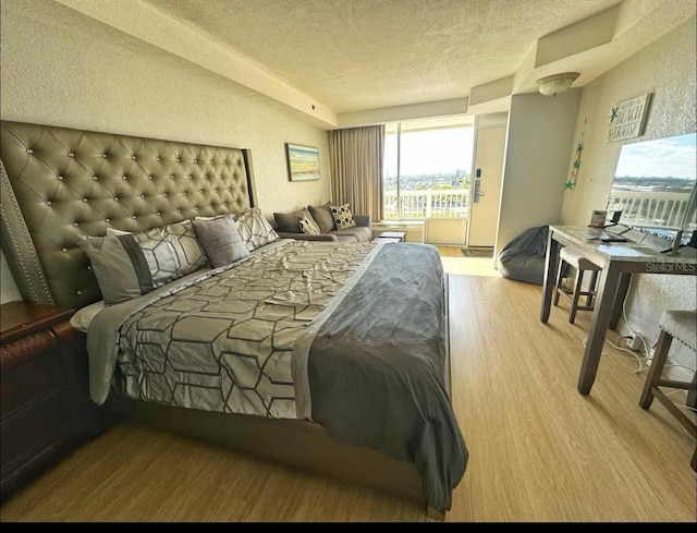 2700 N Atlantic Ave Unit 429, Daytona Beach, FL 32118 - bedroom featuring wood finished floors, multiple windows, and a textured ceiling