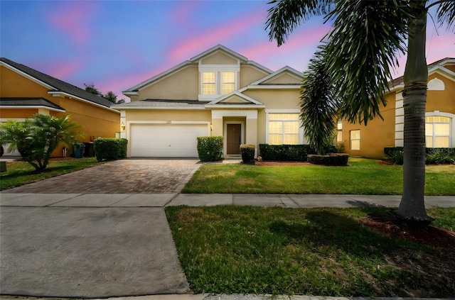 223 Cadiz Loop, Davenport, FL 33837 - traditional-style home with stucco siding, driveway, a lawn, and a garage