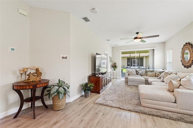 living area featuring light wood-style flooring, ceiling fan, and baseboards