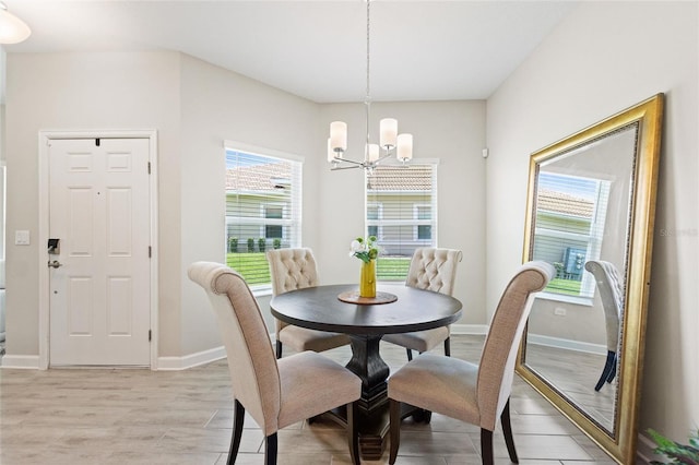 dining area with a chandelier, light wood-style floors, and baseboards