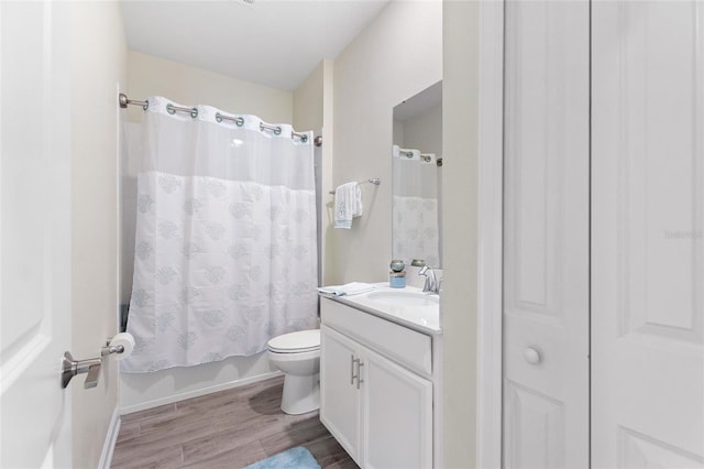 full bath with wood finished floors, toilet, vanity, and shower / tub combo
