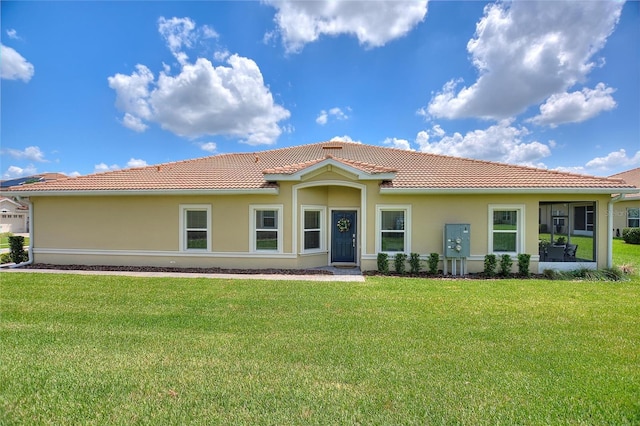 view of front facade with a tile roof, a front lawn, and stucco siding