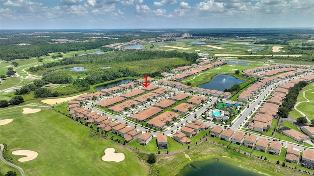 aerial view of property and surrounding area with a large body of water, a golf course, and nearby suburban area