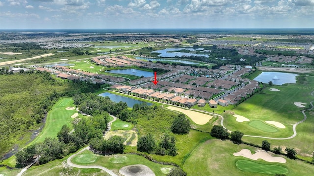 view of property location with a large body of water, a golf club, and nearby suburban area