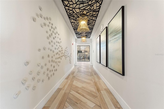 corridor featuring baseboards and light wood-style floors