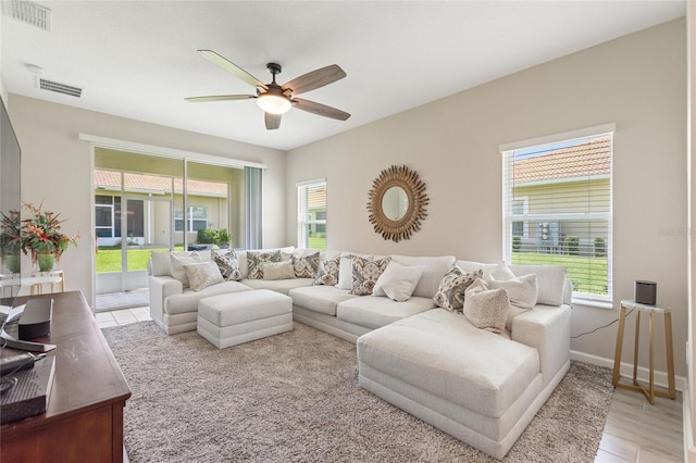 living room featuring a ceiling fan, baseboards, and wood finished floors