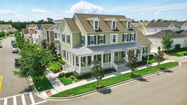 1850 Treasure Cv, Celebration, FL 34747 - view of front of house with a residential view, a porch, metal roof, and a shingled roof