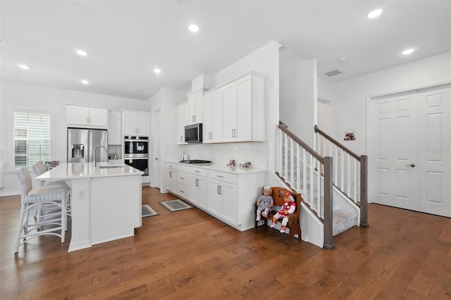 1850 Treasure Cv, Celebration, FL 34747 - kitchen featuring appliances with stainless steel finishes, dark wood-type flooring, white cabinets, and recessed lighting