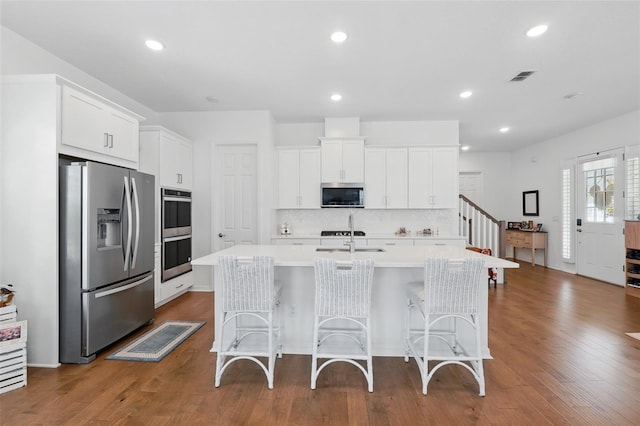 1850 Treasure Cv, Celebration, FL 34747 - kitchen featuring appliances with stainless steel finishes, light countertops, backsplash, white cabinets, and recessed lighting