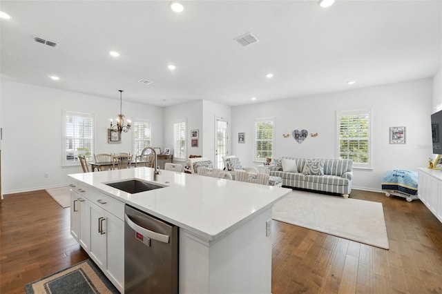 1850 Treasure Cv, Celebration, FL 34747 - kitchen featuring stainless steel dishwasher, a sink, an island with sink, dark wood-style floors, and light countertops