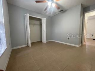 116 Talavera Ln, Kissimmee, FL 34758 - unfurnished bedroom featuring baseboards, a closet, and ceiling fan