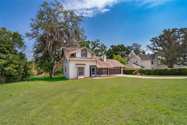 traditional-style house with an attached garage, driveway, and a front yard