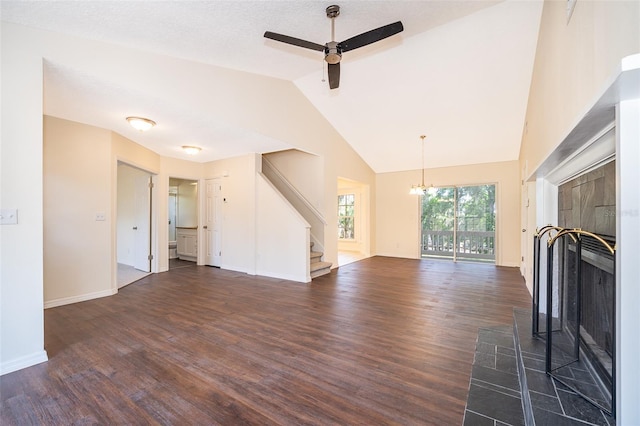 unfurnished living room featuring dark wood-type flooring, stairway, ceiling fan, a chandelier, and high vaulted ceiling
