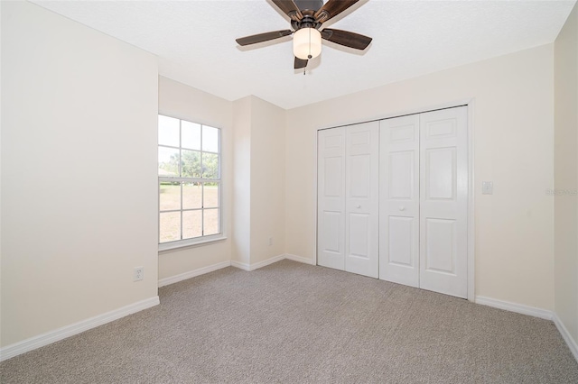 unfurnished bedroom featuring carpet floors, baseboards, a closet, and ceiling fan