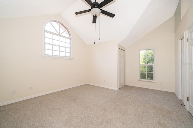 spare room with lofted ceiling, light carpet, baseboards, and a ceiling fan