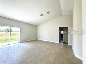 2427 Continental Blvd, Orlando, FL 32808 - unfurnished room with vaulted ceiling and baseboards