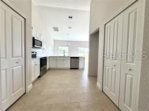 2427 Continental Blvd, Orlando, FL 32808 - kitchen featuring stainless steel appliances, white cabinetry, a peninsula, and light countertops