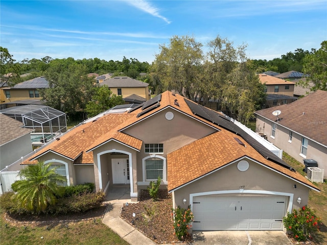 149 Imperial Oak Ct, Davenport, FL 33896 - view of front of property with stucco siding, roof mounted solar panels, central air condition unit, concrete driveway, and a garage