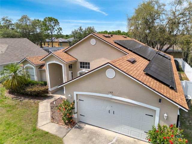 149 Imperial Oak Ct, Davenport, FL 33896 - mediterranean / spanish home featuring roof mounted solar panels, stucco siding, roof with shingles, a garage, and concrete driveway