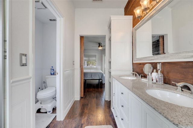 149 Imperial Oak Ct, Davenport, FL 33896 - ensuite bathroom featuring toilet, wood finished floors, double vanity, and a ceiling fan