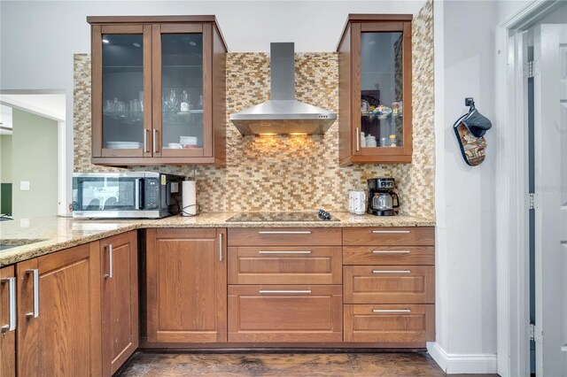 149 Imperial Oak Ct, Davenport, FL 33896 - kitchen with wall chimney exhaust hood, stainless steel microwave, black electric stovetop, tasteful backsplash, and light stone countertops