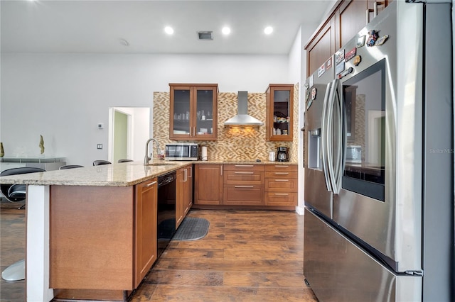 149 Imperial Oak Ct, Davenport, FL 33896 - kitchen featuring stainless steel appliances, wall chimney range hood, a peninsula, dark wood-type flooring, and backsplash