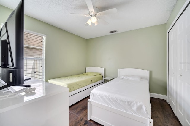 149 Imperial Oak Ct, Davenport, FL 33896 - bedroom featuring a closet, dark wood-style flooring, ceiling fan, a textured ceiling, and baseboards