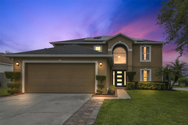 102 Royalty Cir, Sanford, FL 32771 - view of front of property with driveway, an attached garage, a front lawn, stucco siding, and solar panels
