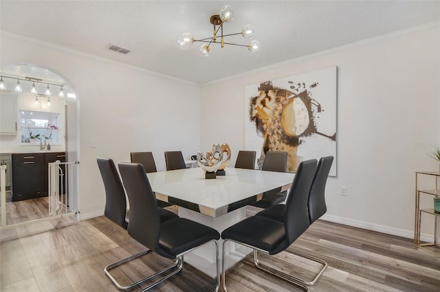 102 Royalty Cir, Sanford, FL 32771 - dining space with light wood finished floors, a chandelier, ornamental molding, and baseboards