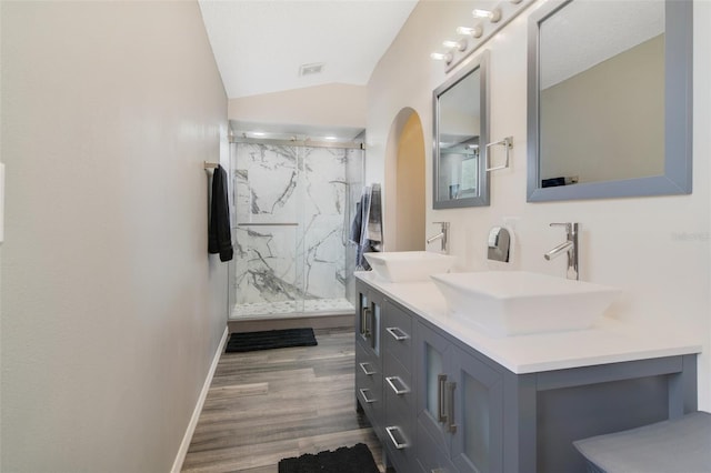 102 Royalty Cir, Sanford, FL 32771 - bathroom featuring double vanity, baseboards, a marble finish shower, wood finished floors, and lofted ceiling